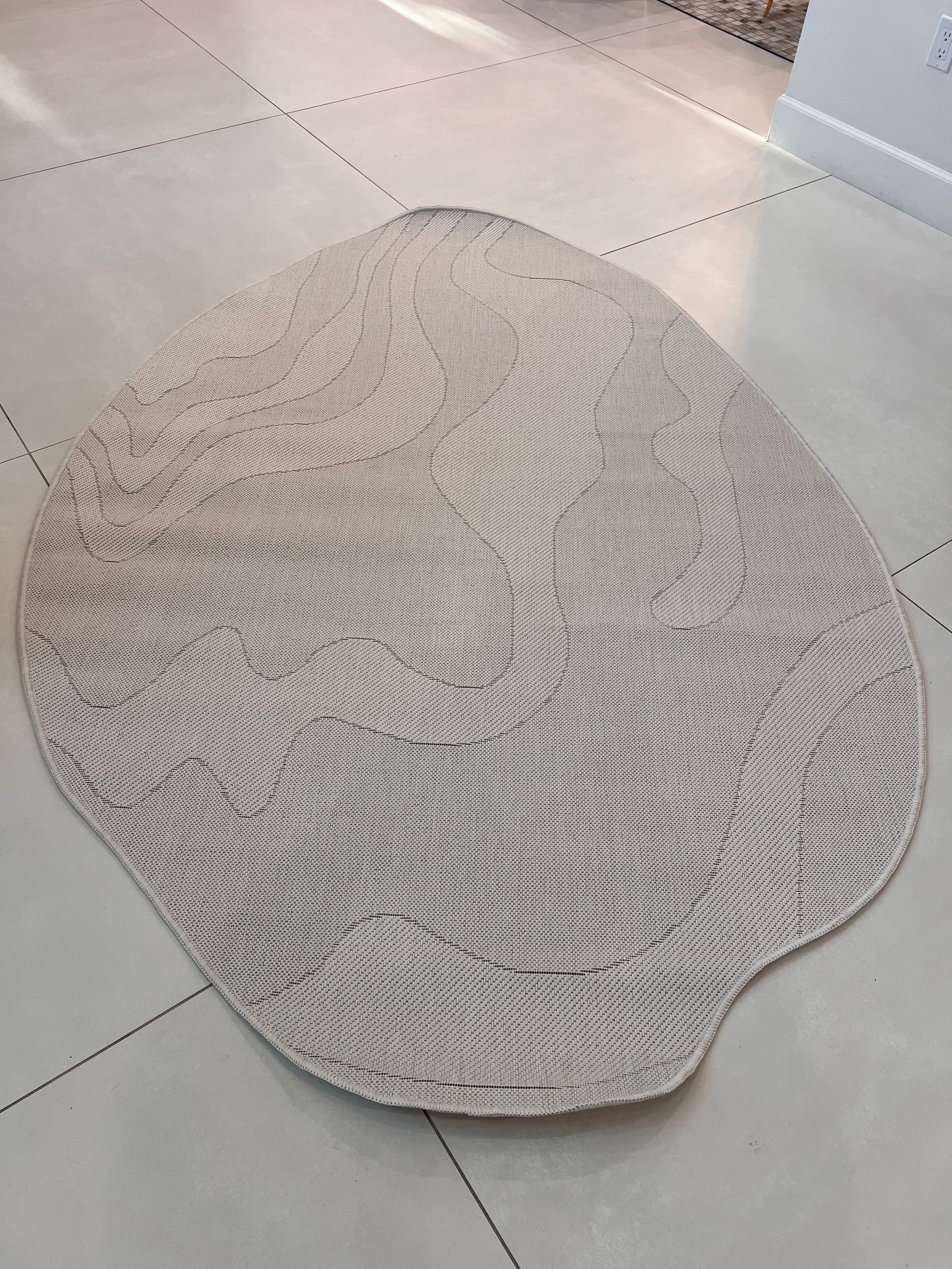 Ivory Indoor/Outdoor Rug with Organic Irregular Shape and Warm Mocha Accents.