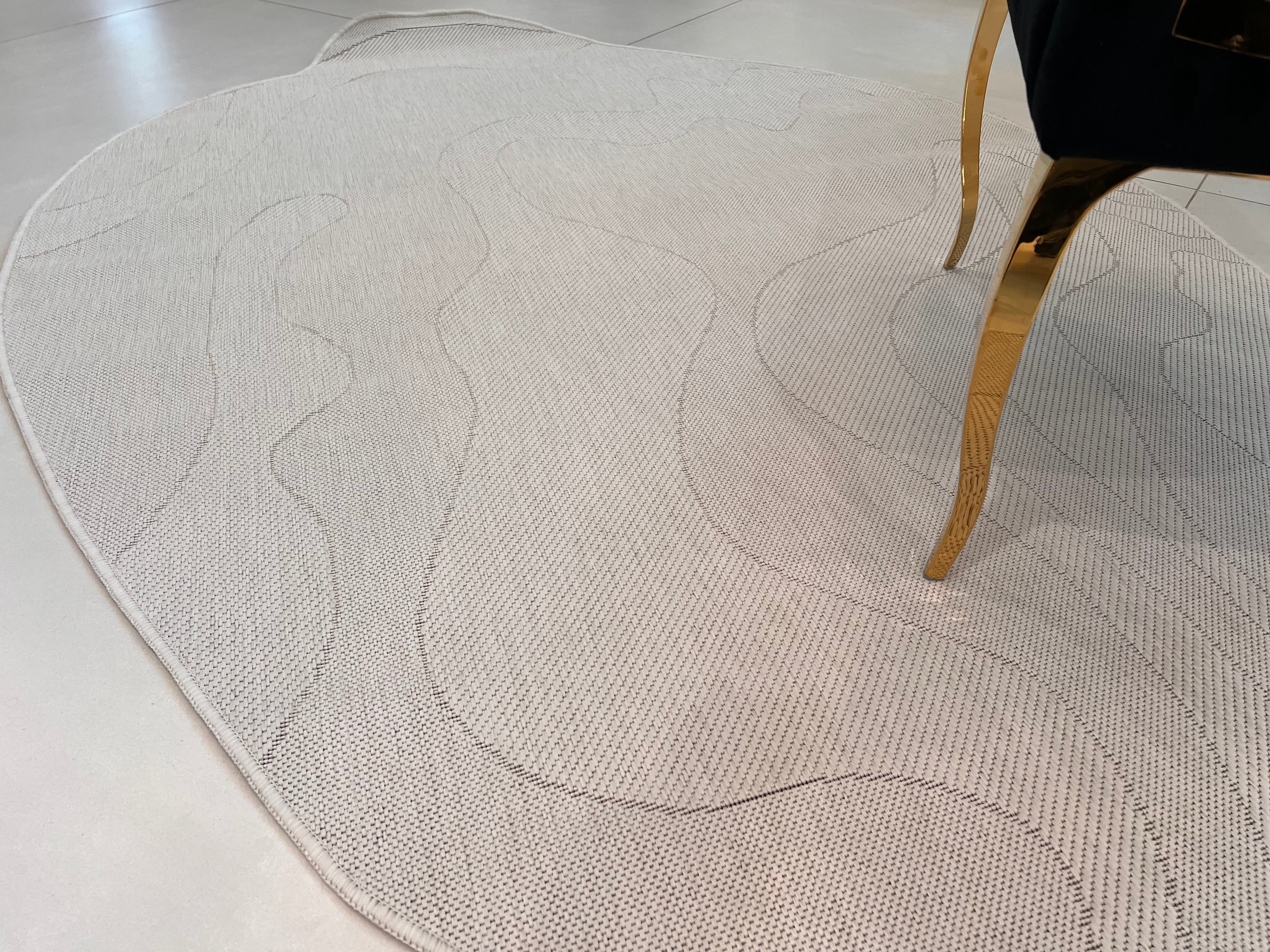 Ivory Indoor/Outdoor Rug with Organic Irregular Shape and Warm Mocha Accents.