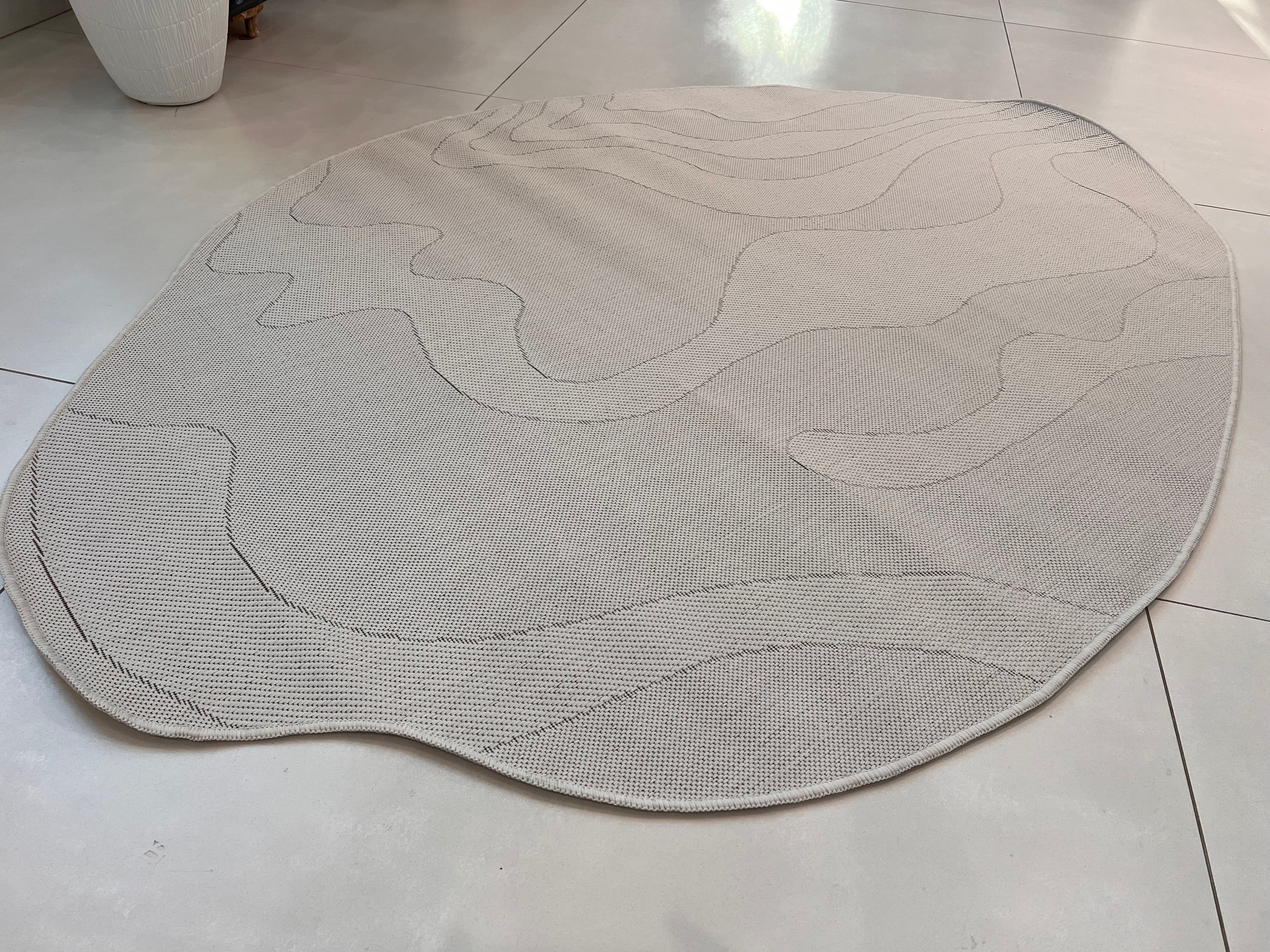 Ivory Indoor/Outdoor Rug with Organic Irregular Shape and Warm Mocha Accents.