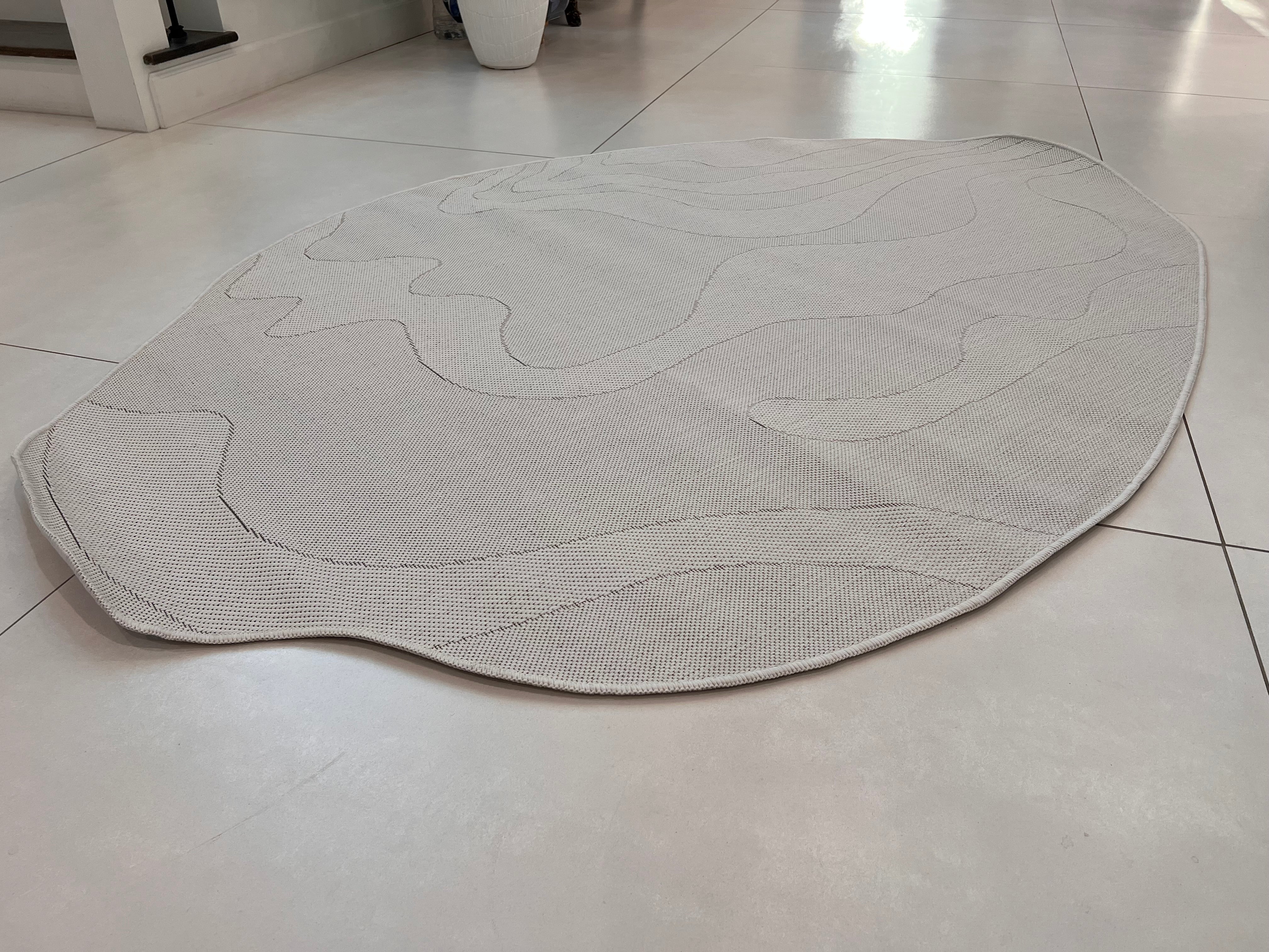 Ivory Indoor/Outdoor Rug with Organic Irregular Shape and Warm Mocha Accents.