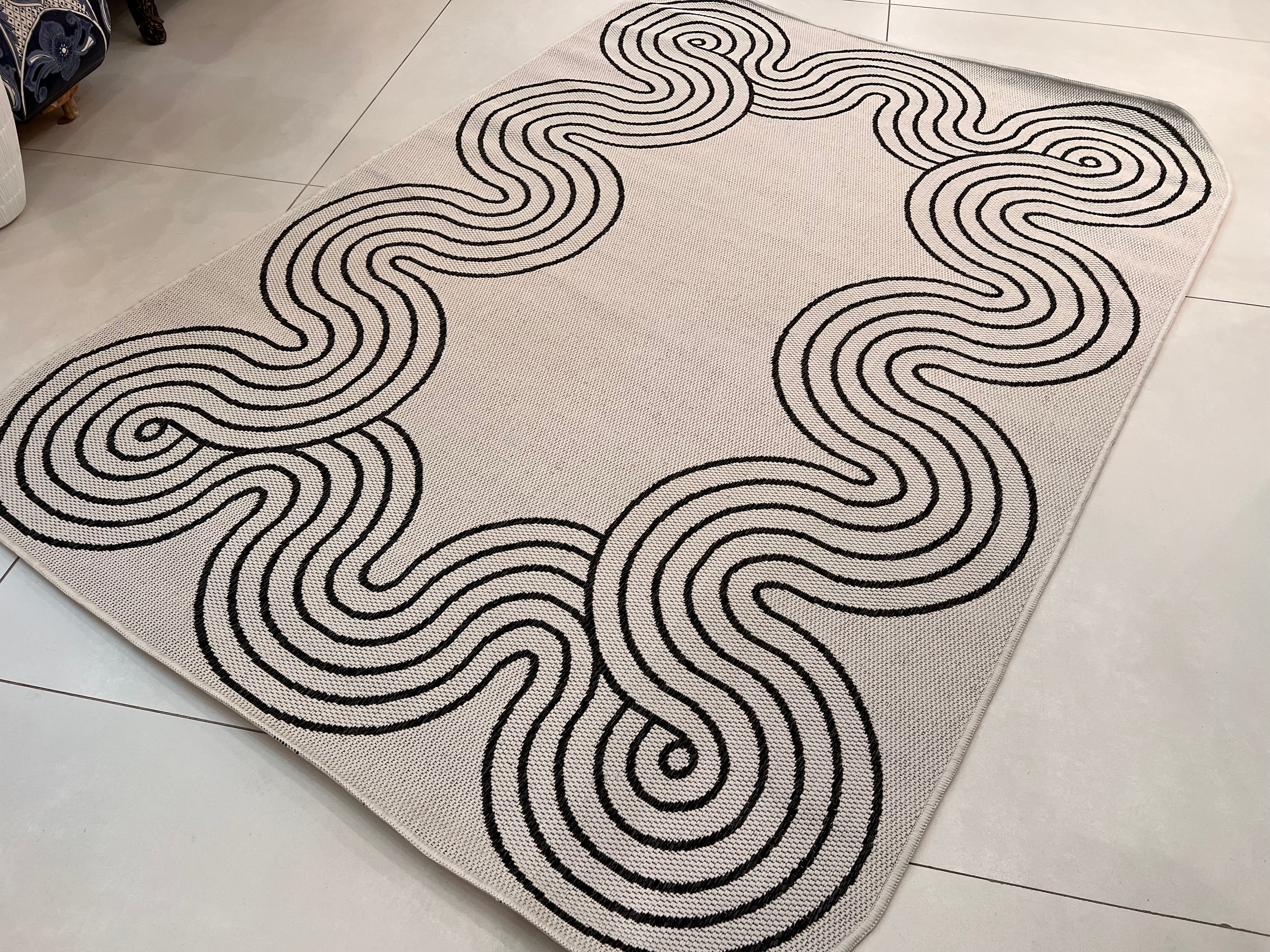 Indoor/Outdoor Ivory Rug with Black Geometric Swirl and Live Edge Design.