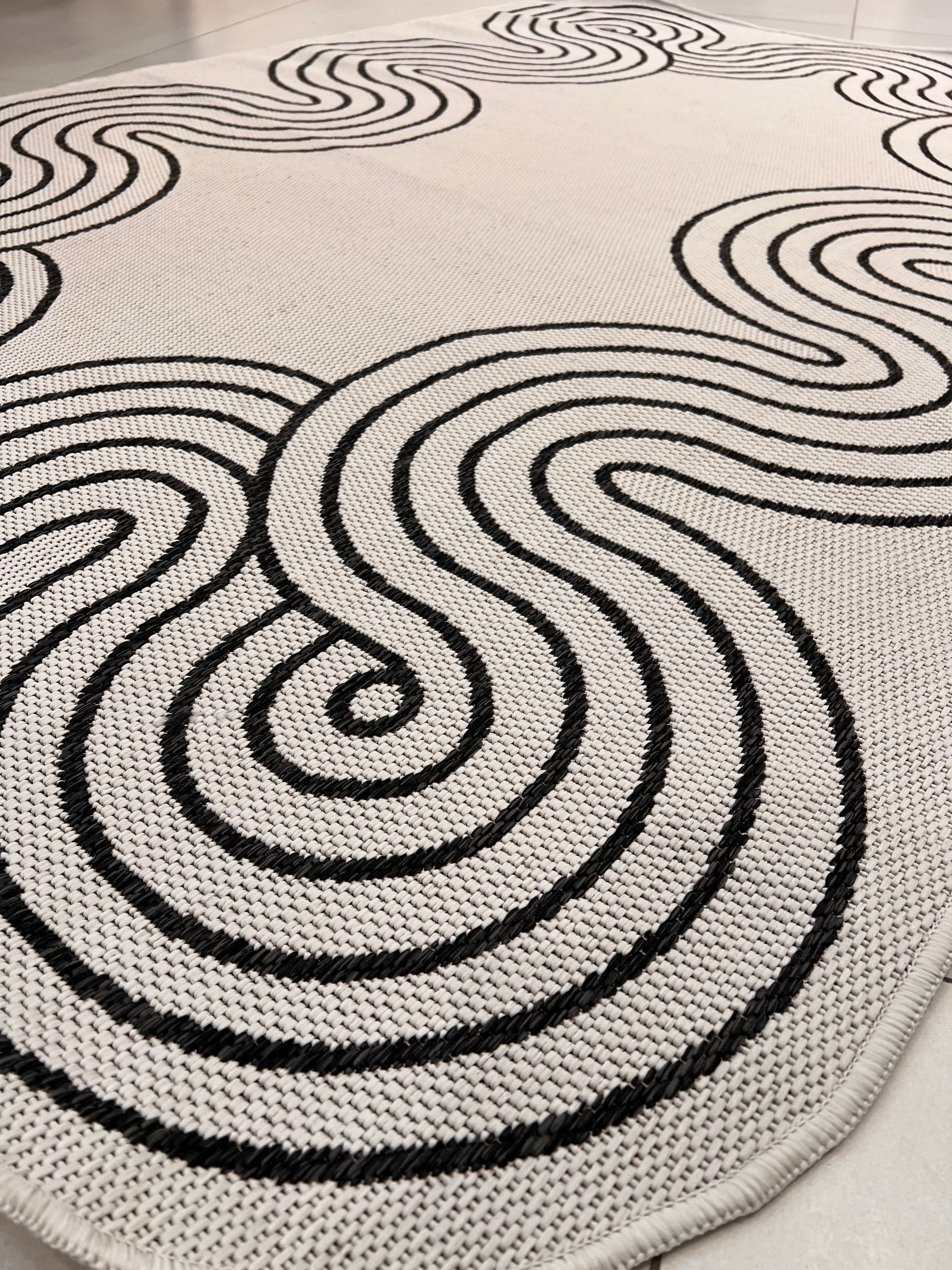 Indoor/Outdoor Ivory Rug with Black Geometric Swirl and Live Edge Design.